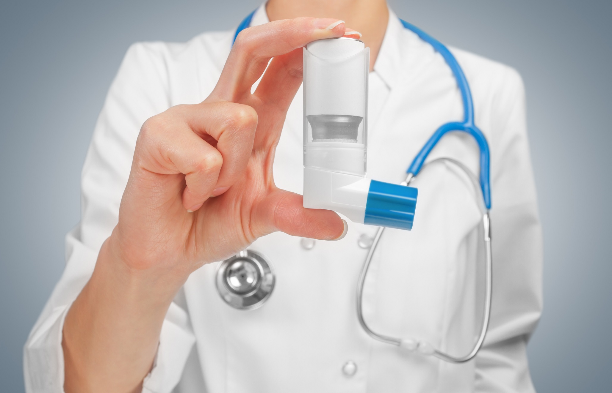 Doctor is holding an inhaler in her hand.
