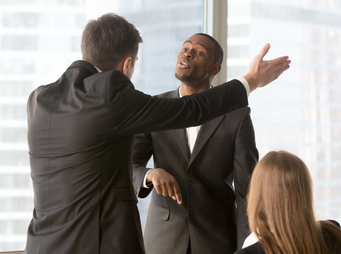 Two young people wearing suits are arguing at office.