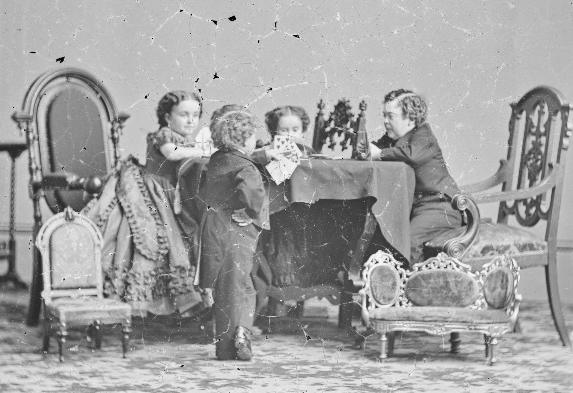 B&W photo of Lavinia Warren wearing black dress and playing cards with other people - 1860s