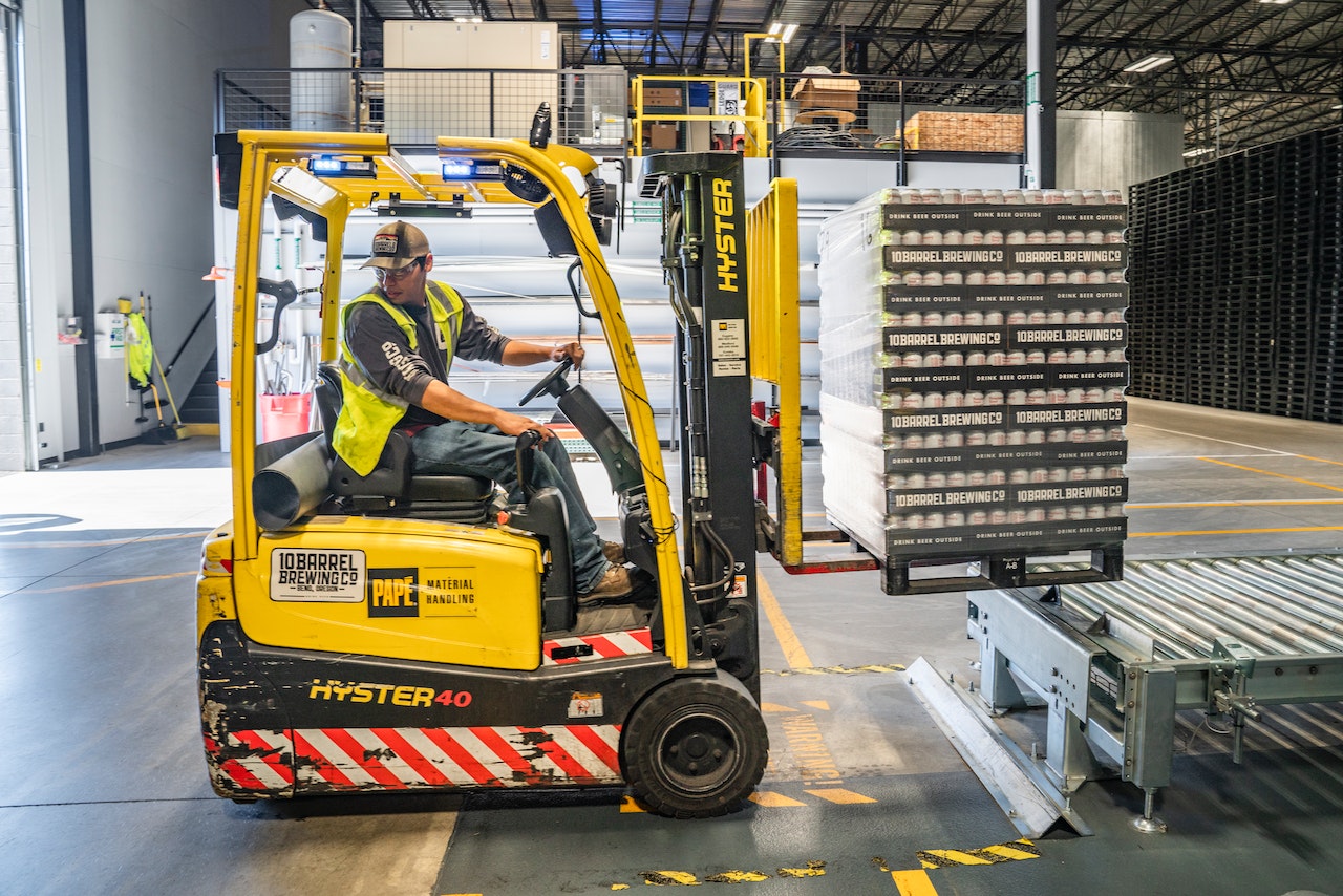 Young person in uniform is using the forklift.