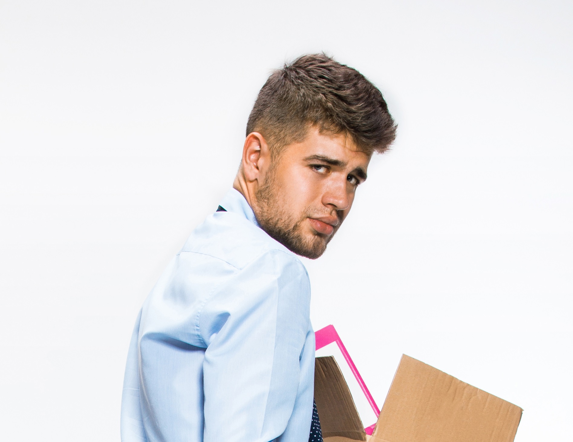 Young man is holding a box and looking at camera with sad face - FIRED.