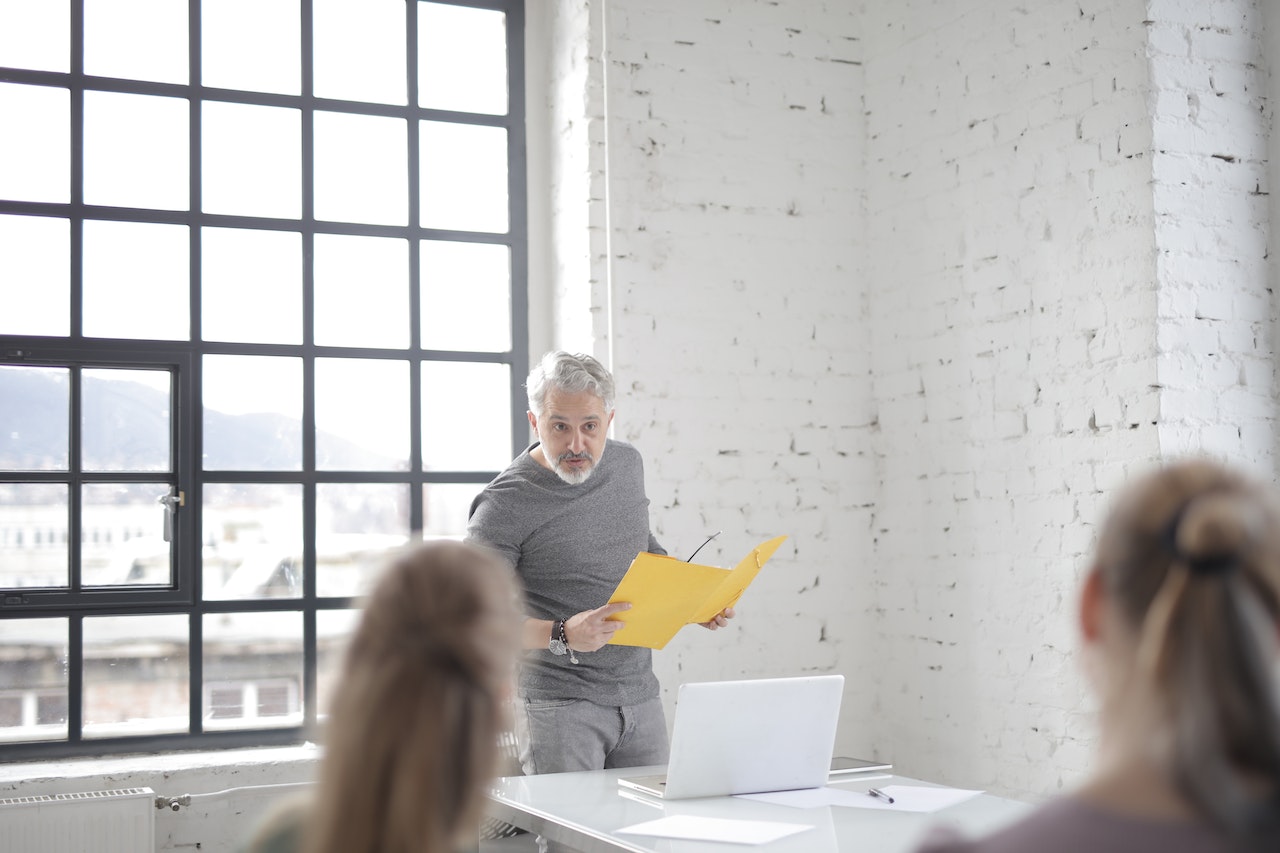 Senior man is having a meeting with other people in office.