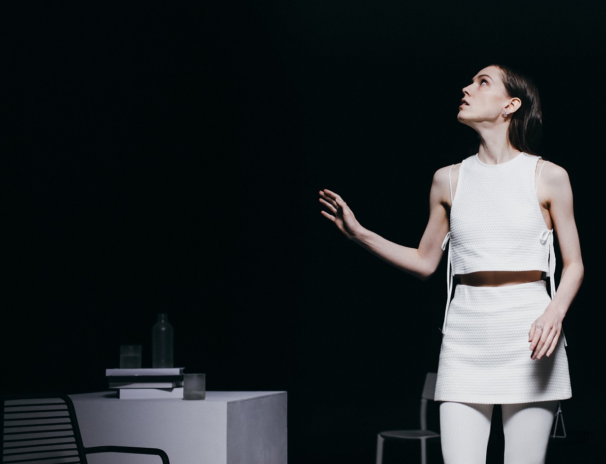 Woman is looking up in room with dark walls.