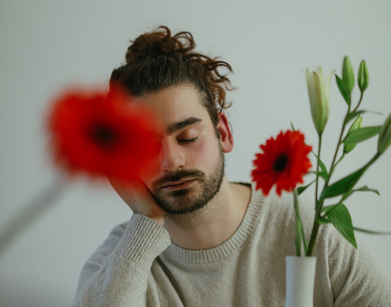 Young bearded man is sleeping on the kitchen table.