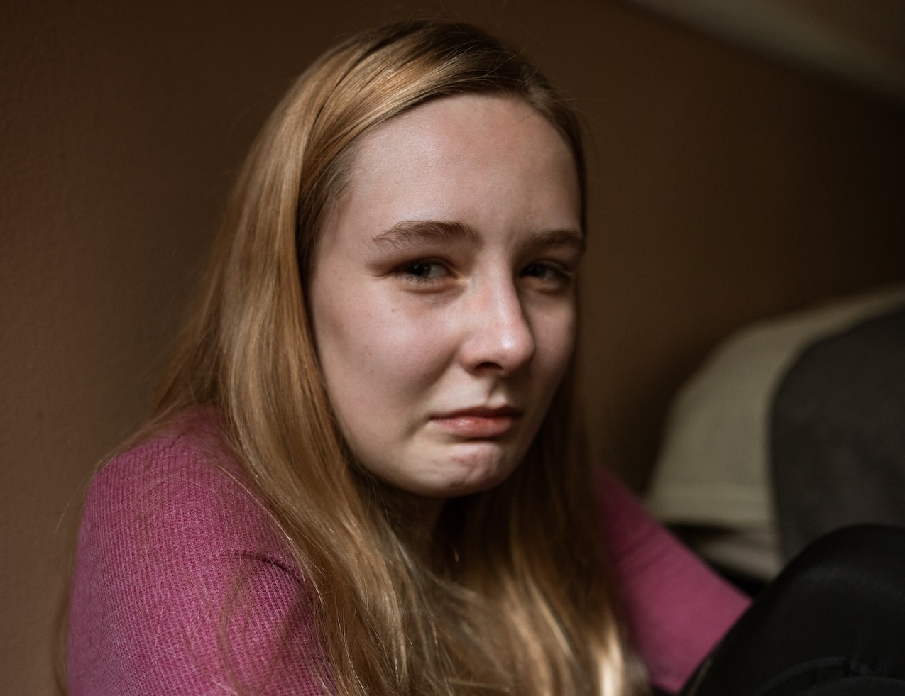 Scared girl is crying and looking at camera.