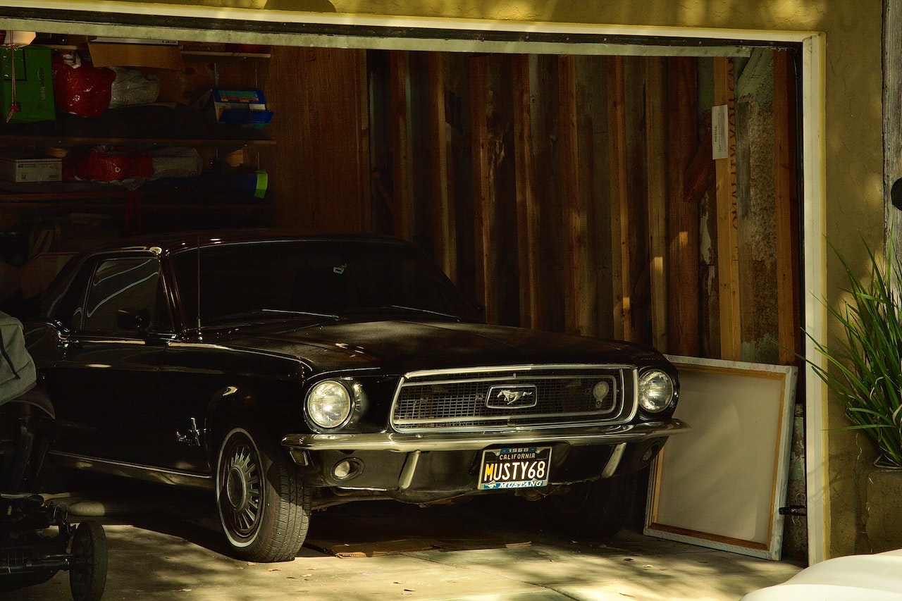 A black vintage ford mustang parked in the garage.
