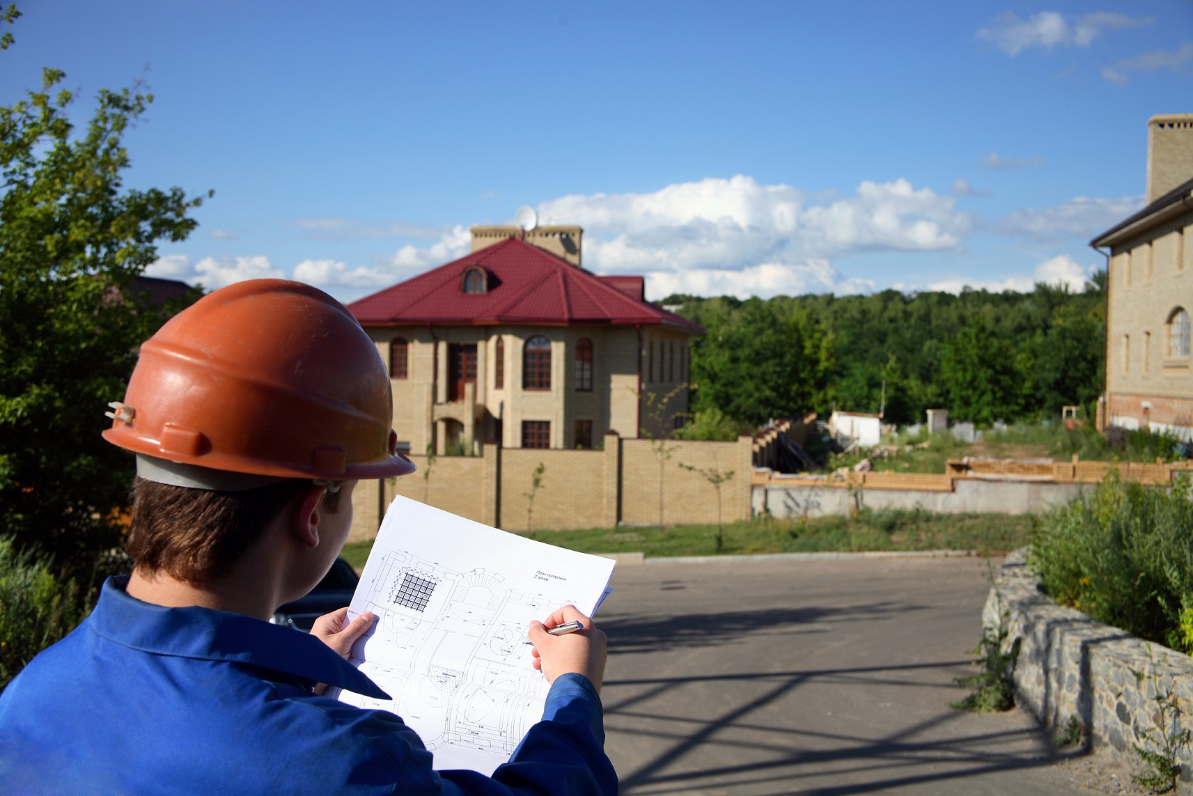 Man with the plan of construction and helmet.