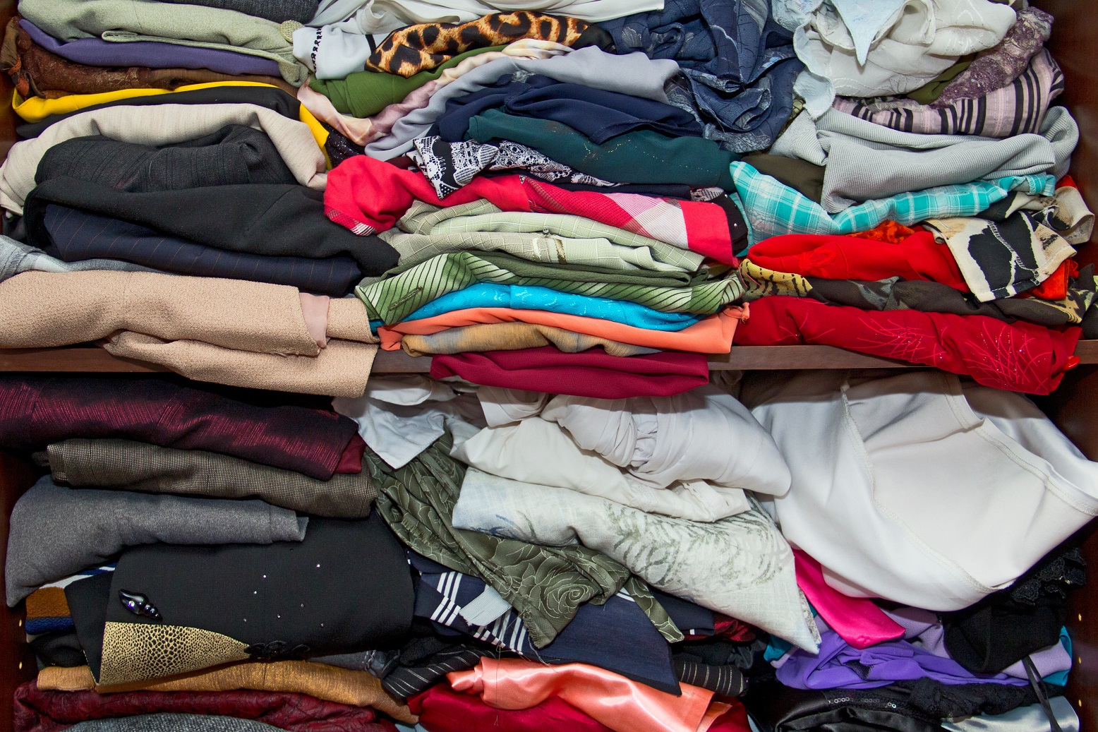 Clothes in piles stacked over.