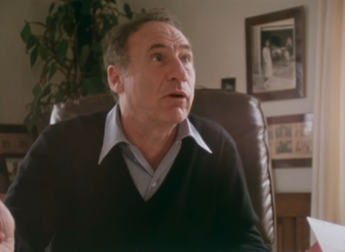 Screenshot: Mel Brooks wearing blue shirt and black sweater is looking at side with surprised face - from Mel Brooks-Unwrapped (2018)