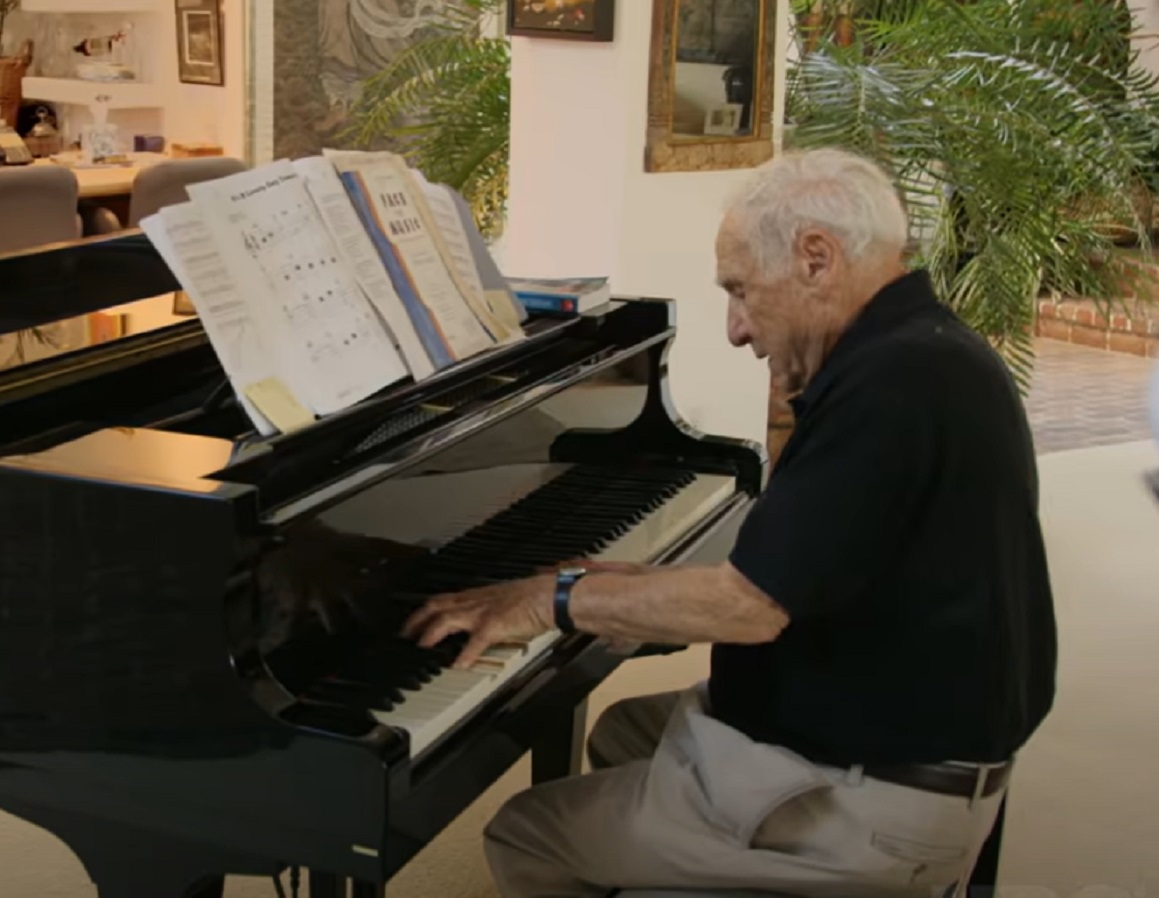 Screenshot: Mel Brooks is playing on black piano - from Mel Brooks-Unwrapped (2018).