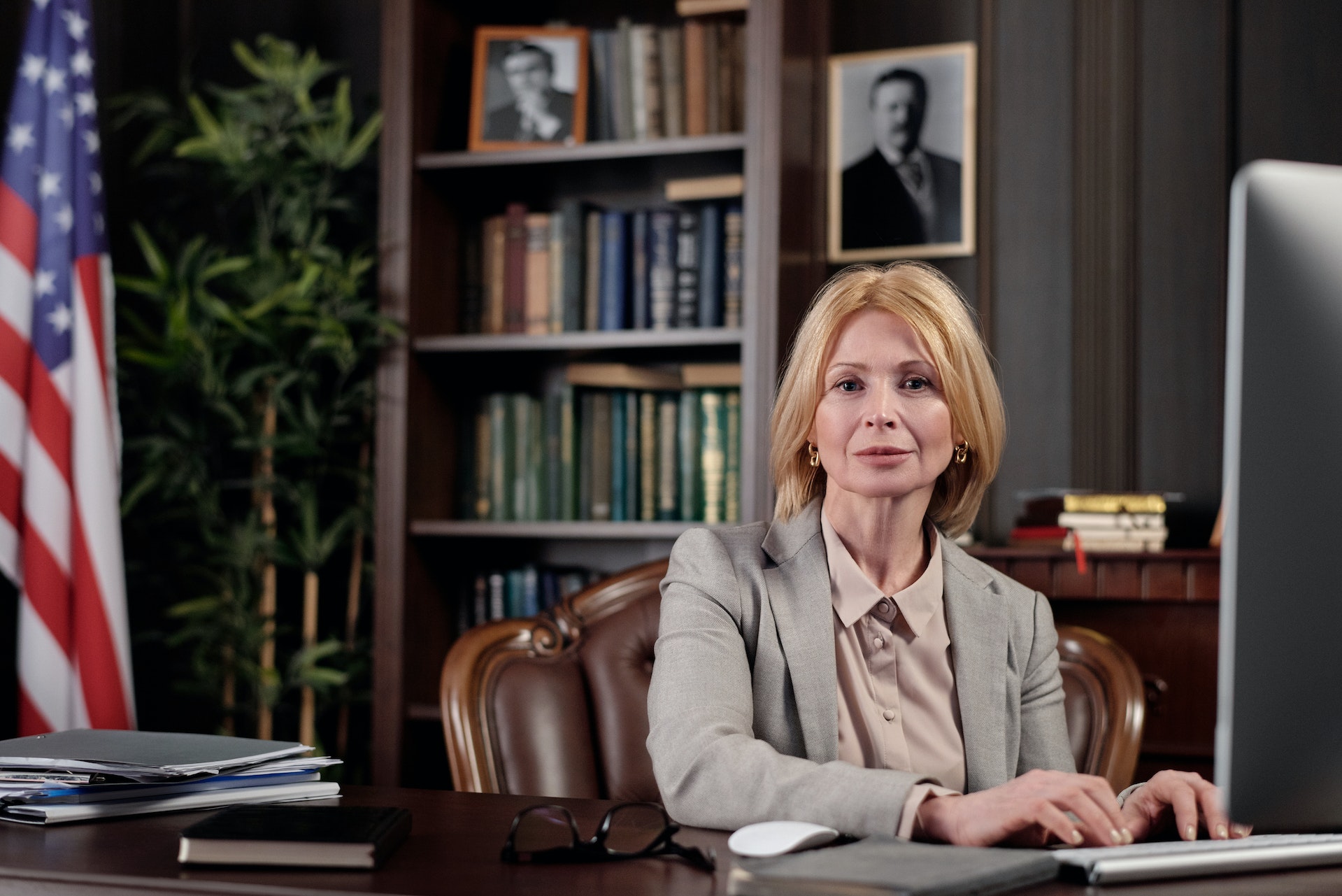 A lawyer sitting in her office at a desk working on a computer in gray suit