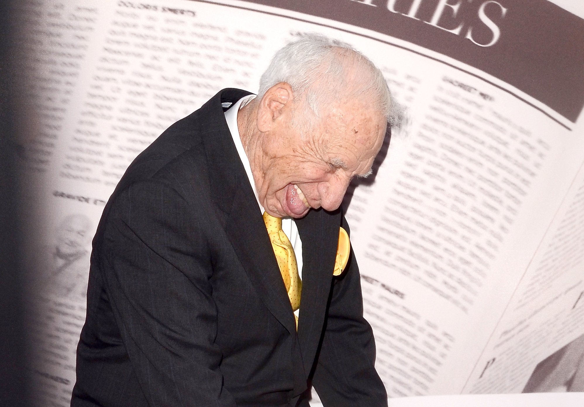 Mel Brooks wearing black suit and yellow tie is making a face gesture - 2017