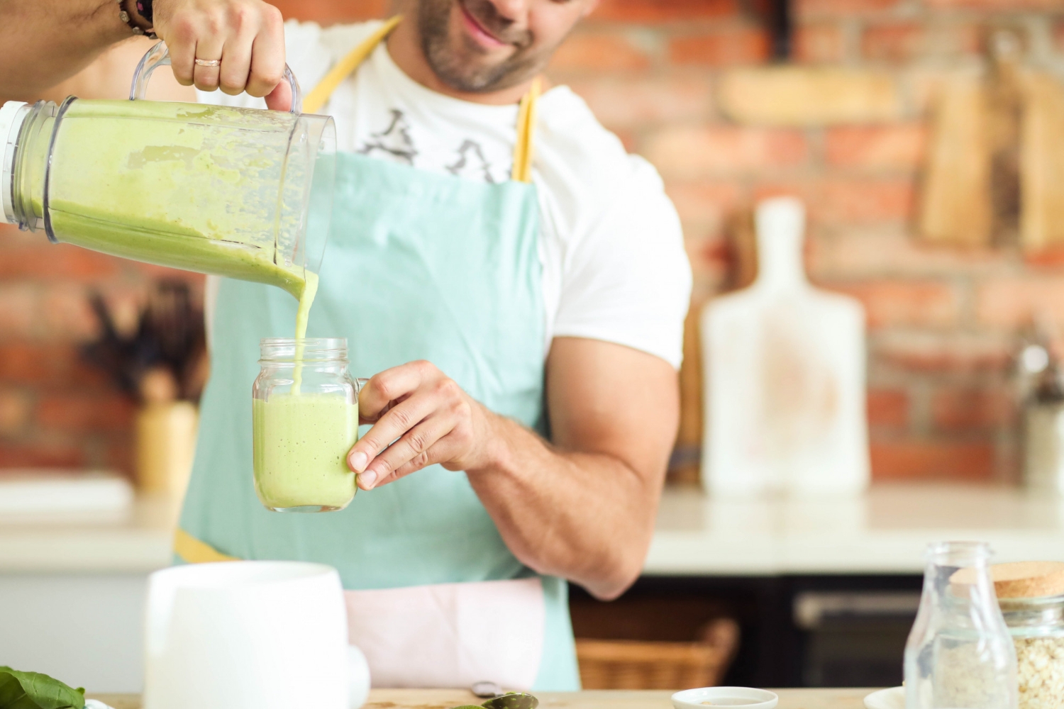 Chef is making a green smoothie in the kitchen.