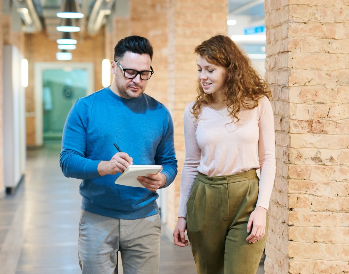 Two young people are walking at hallway.