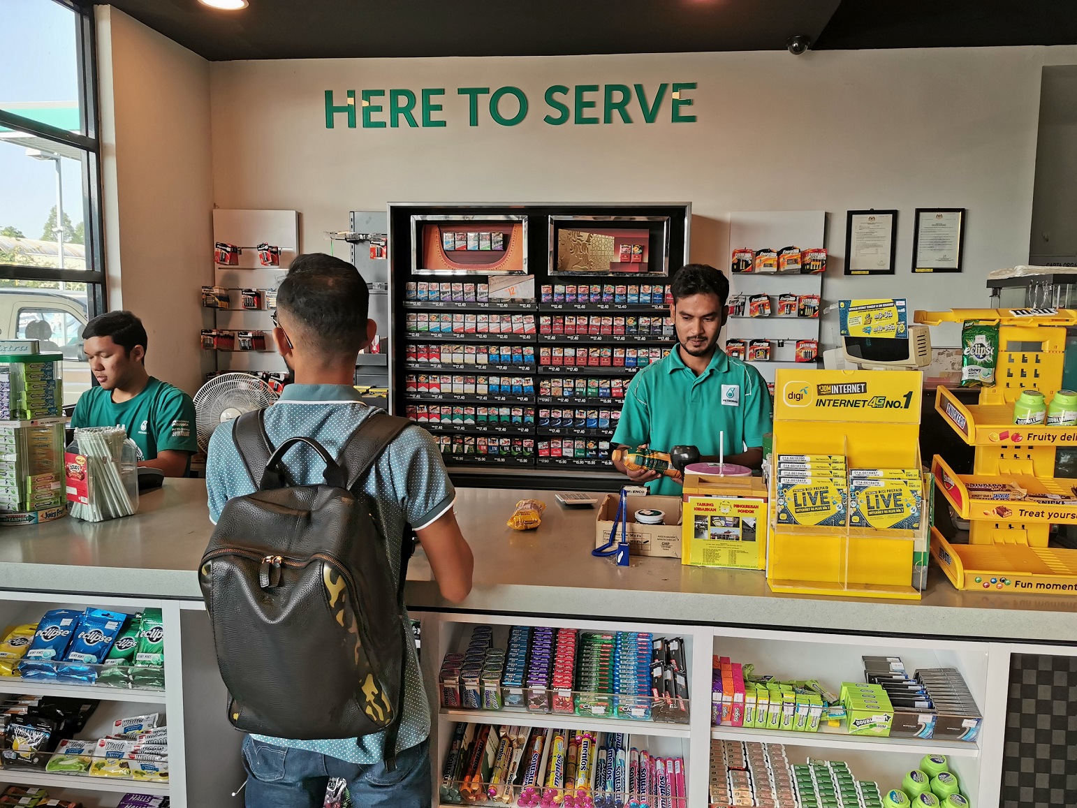 Gas station cashier is working at gas station store.