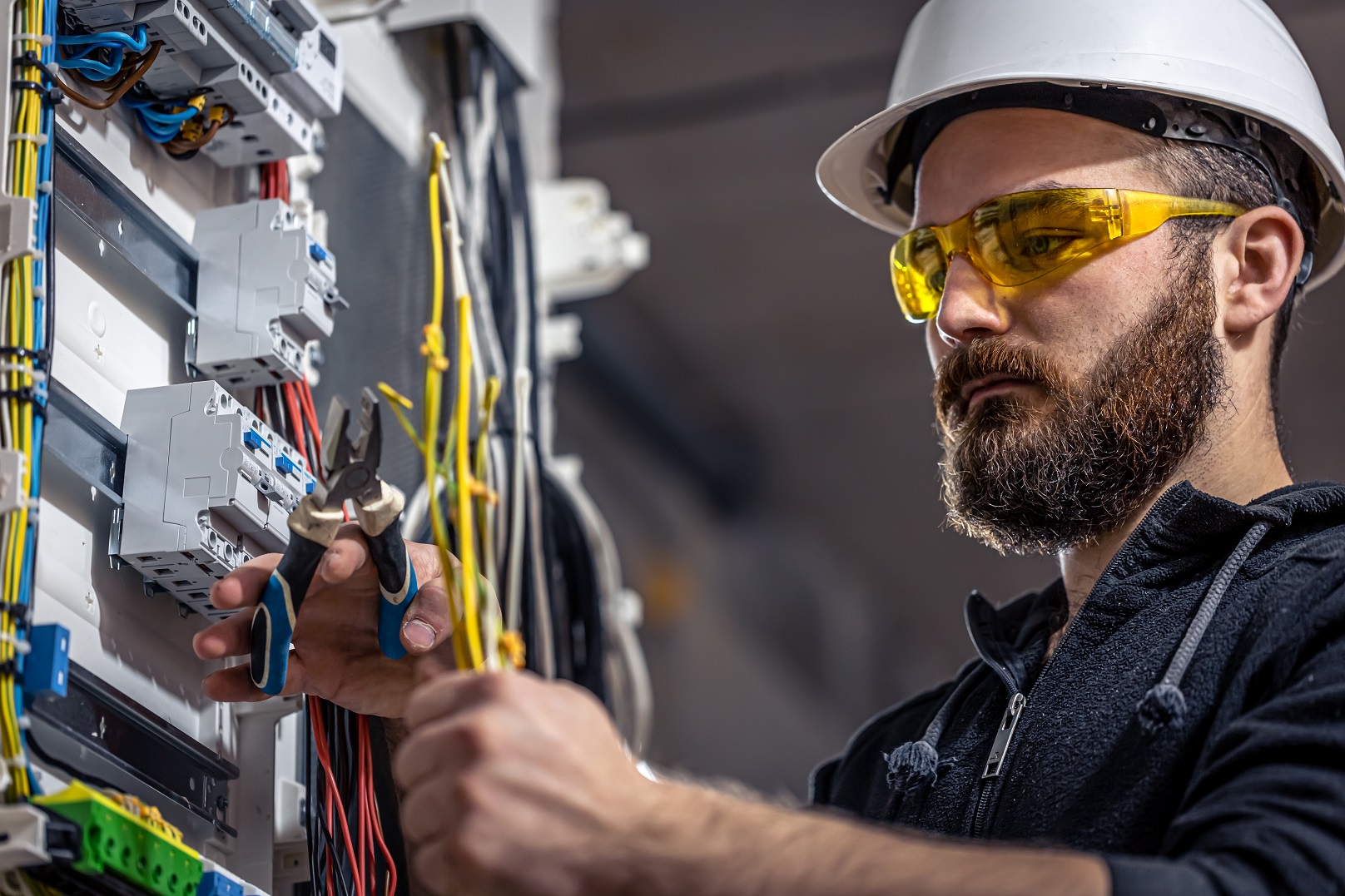 A electrician is working on switchboard.