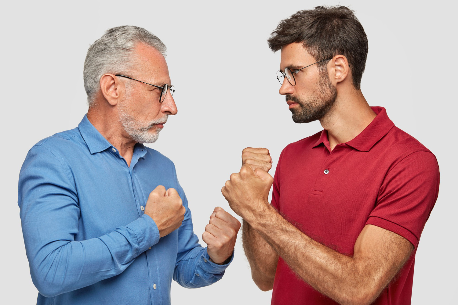 Senior man with beard is making a fight pose and looking at upset young man.