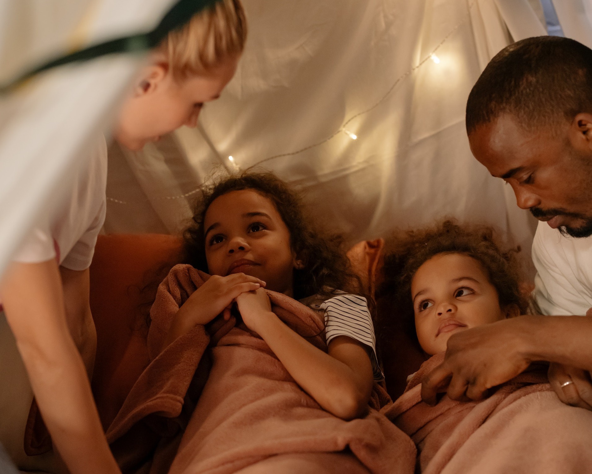 Kids are having a camping night in tent ,looking at parents.