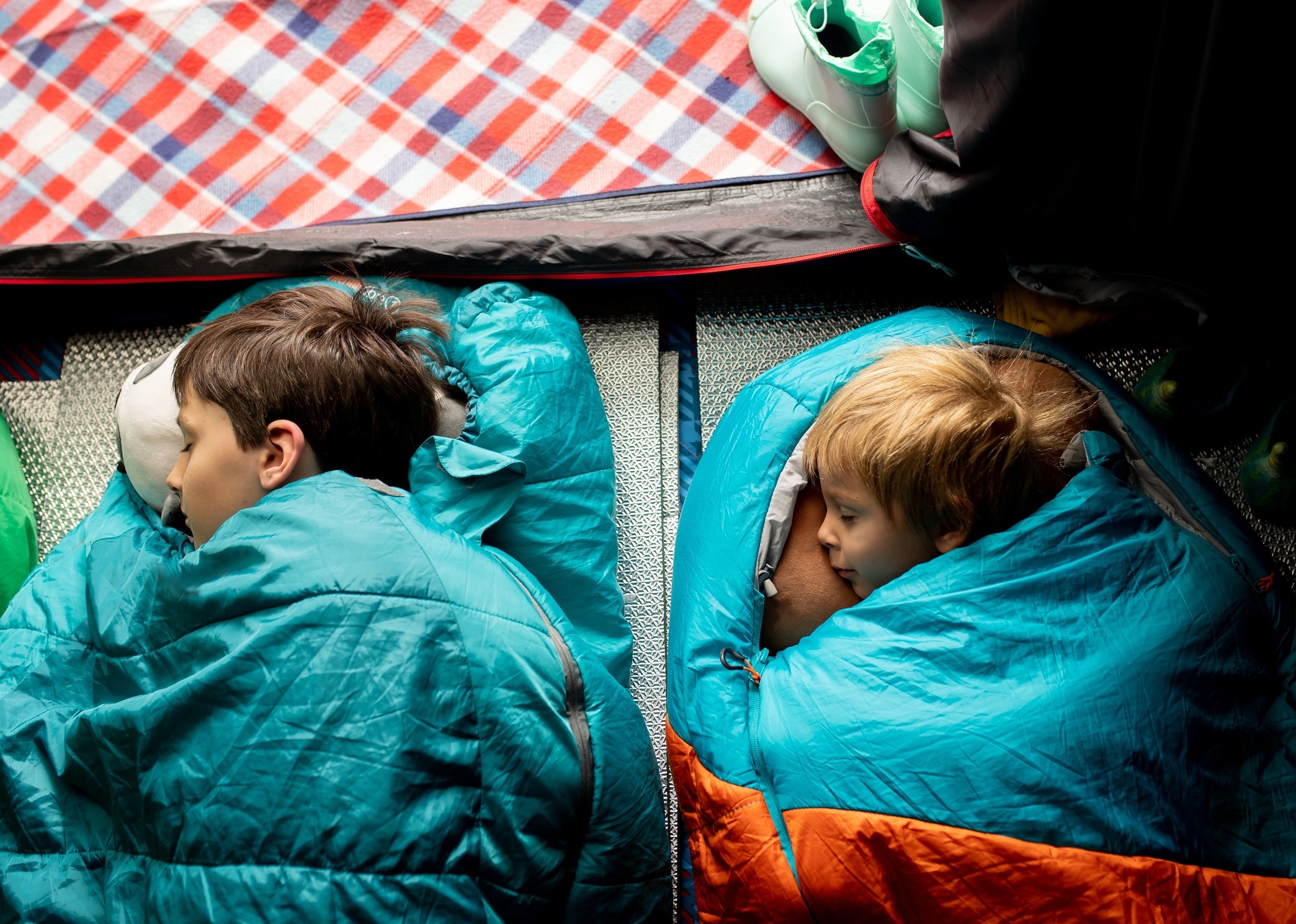 Children are sleeping in sleeping bags in basement.