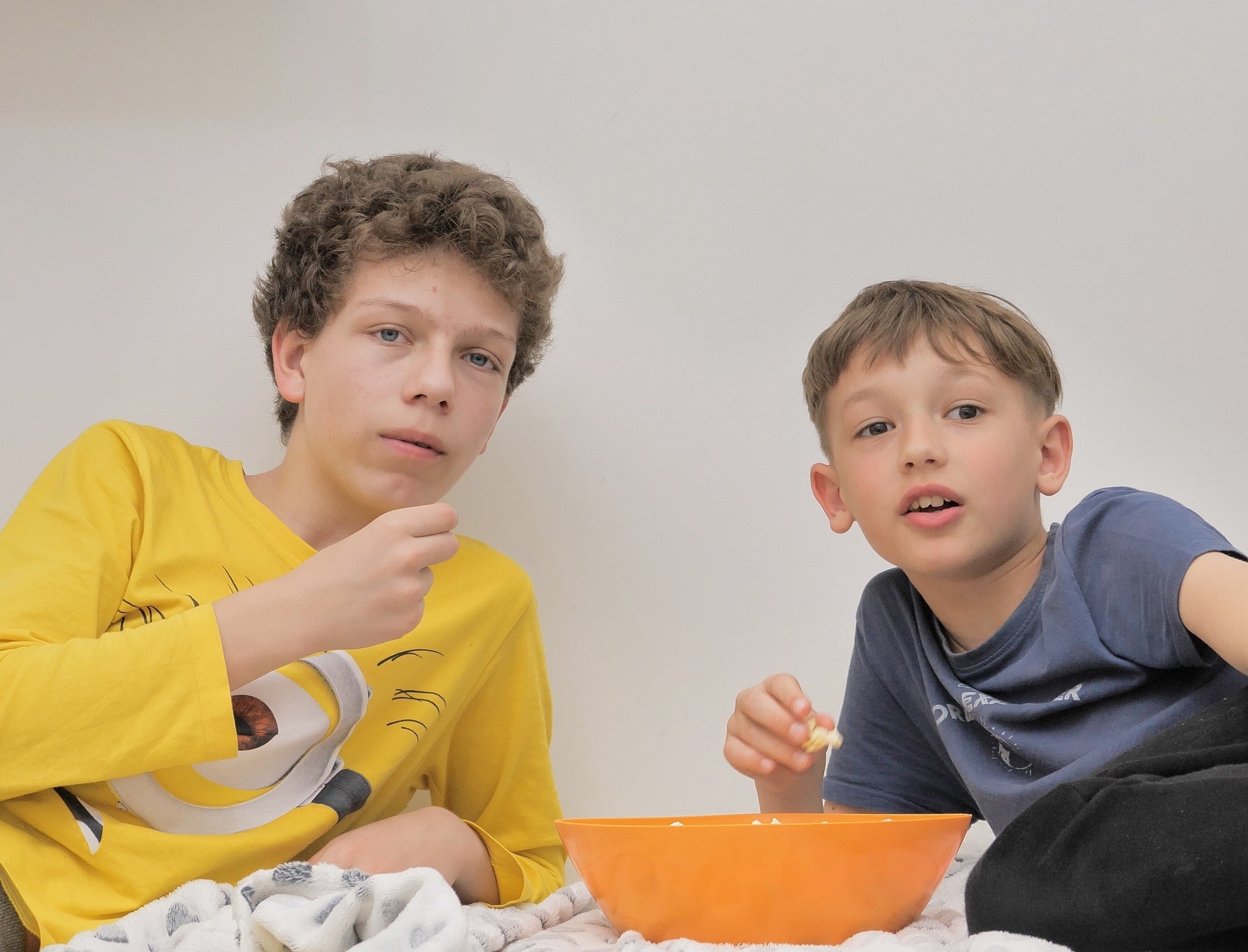 Two young boys are looking at front with upset faces.
