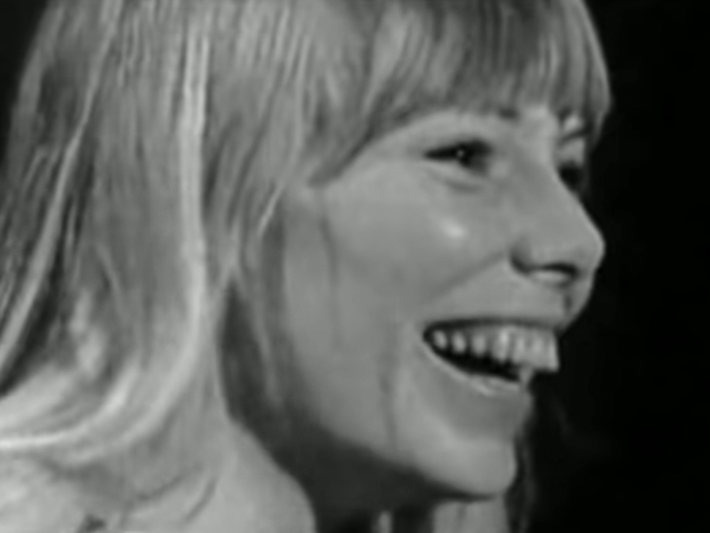 B&W Screenshot: Joni Mitchell is smiling and looking at side - from Joni Mitchell: A Woman of Heart and Mind (2003)