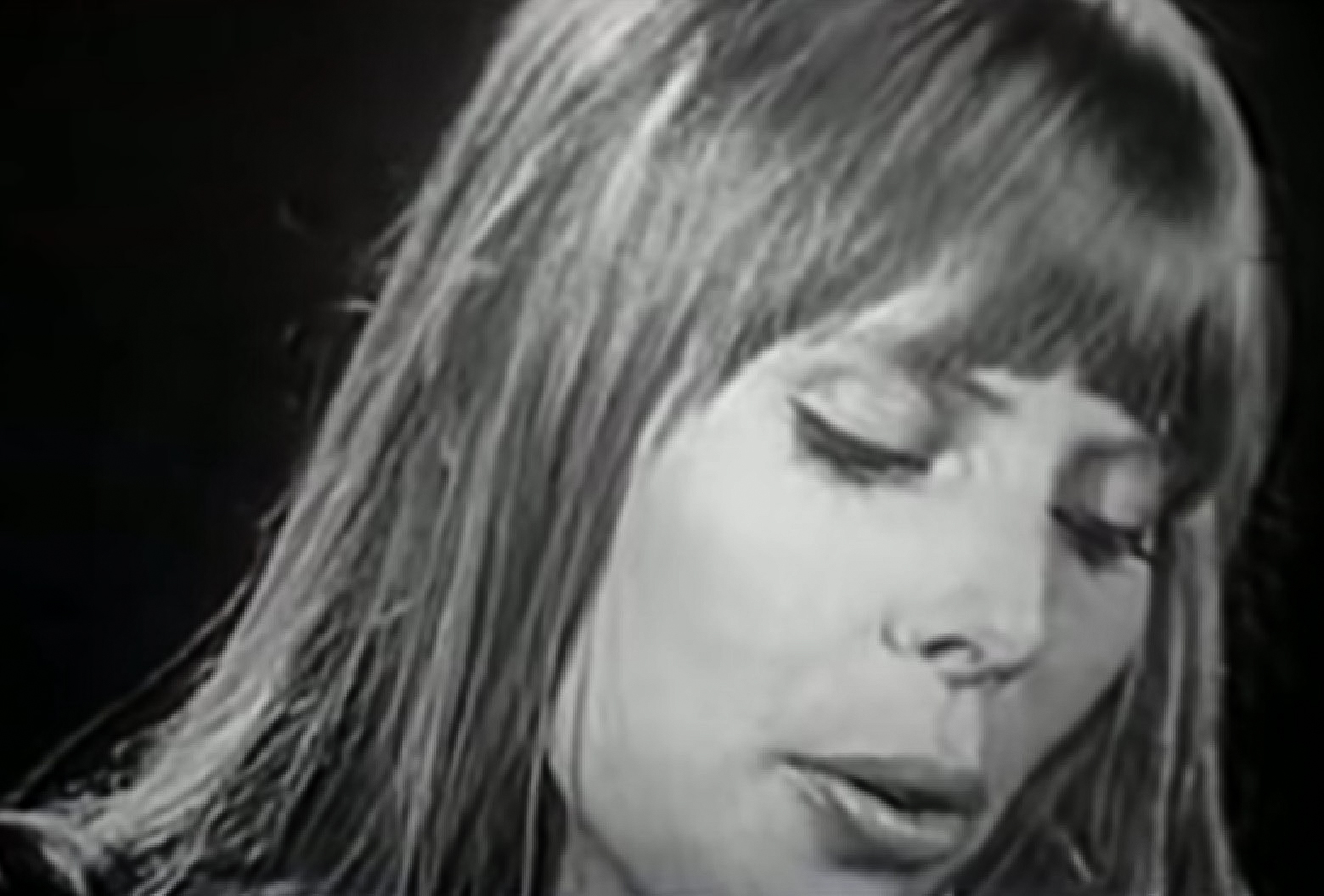 B&W Screenshot: Joni Mitchell is singing and looking down - from Joni Mitchell: A Woman of Heart and Mind (2003)