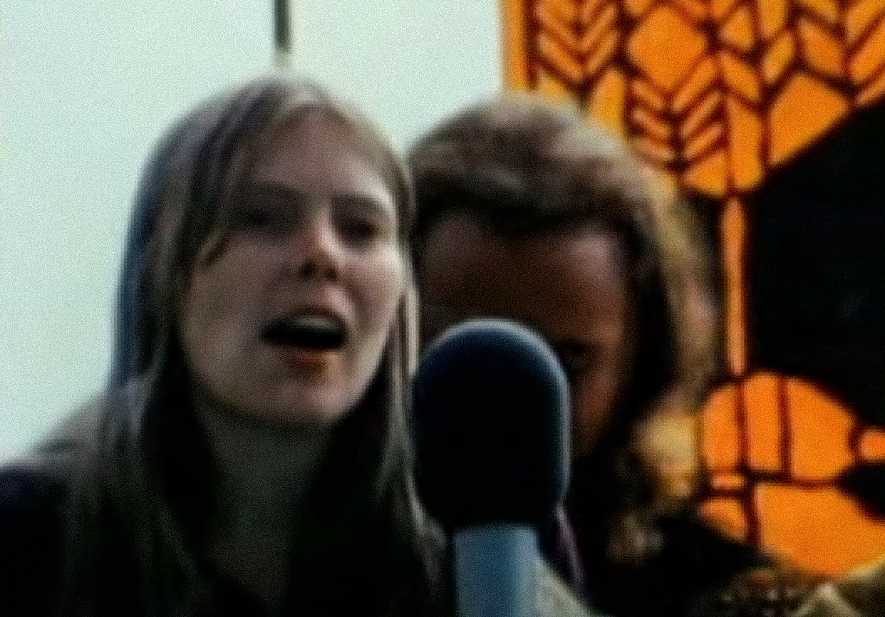 Screenshot: Joni Mitchell is singing on stage - from Joni Mitchell: A Woman of Heart and Mind (2003)