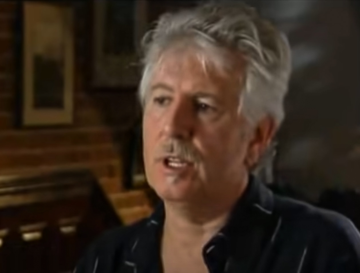 Screenshot: Graham Nash is looking at side and talking - from Joni Mitchell: A Woman of Heart and Mind (2003)