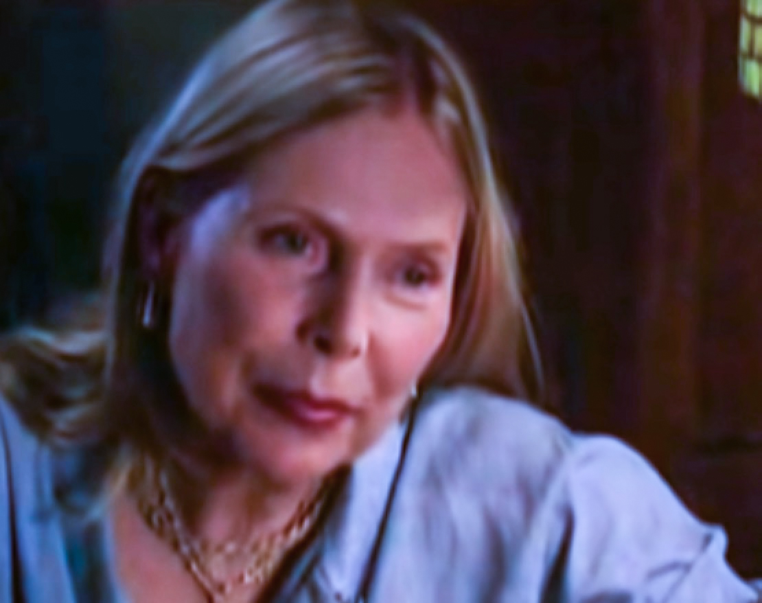 Screenshot: Joni Mitchell wearing blue shirt is looking at side - from Joni Mitchell: A Woman of Heart and Mind (2003).
