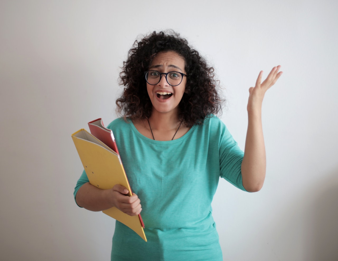 Young woman is looking happy and holding papers in her hand.