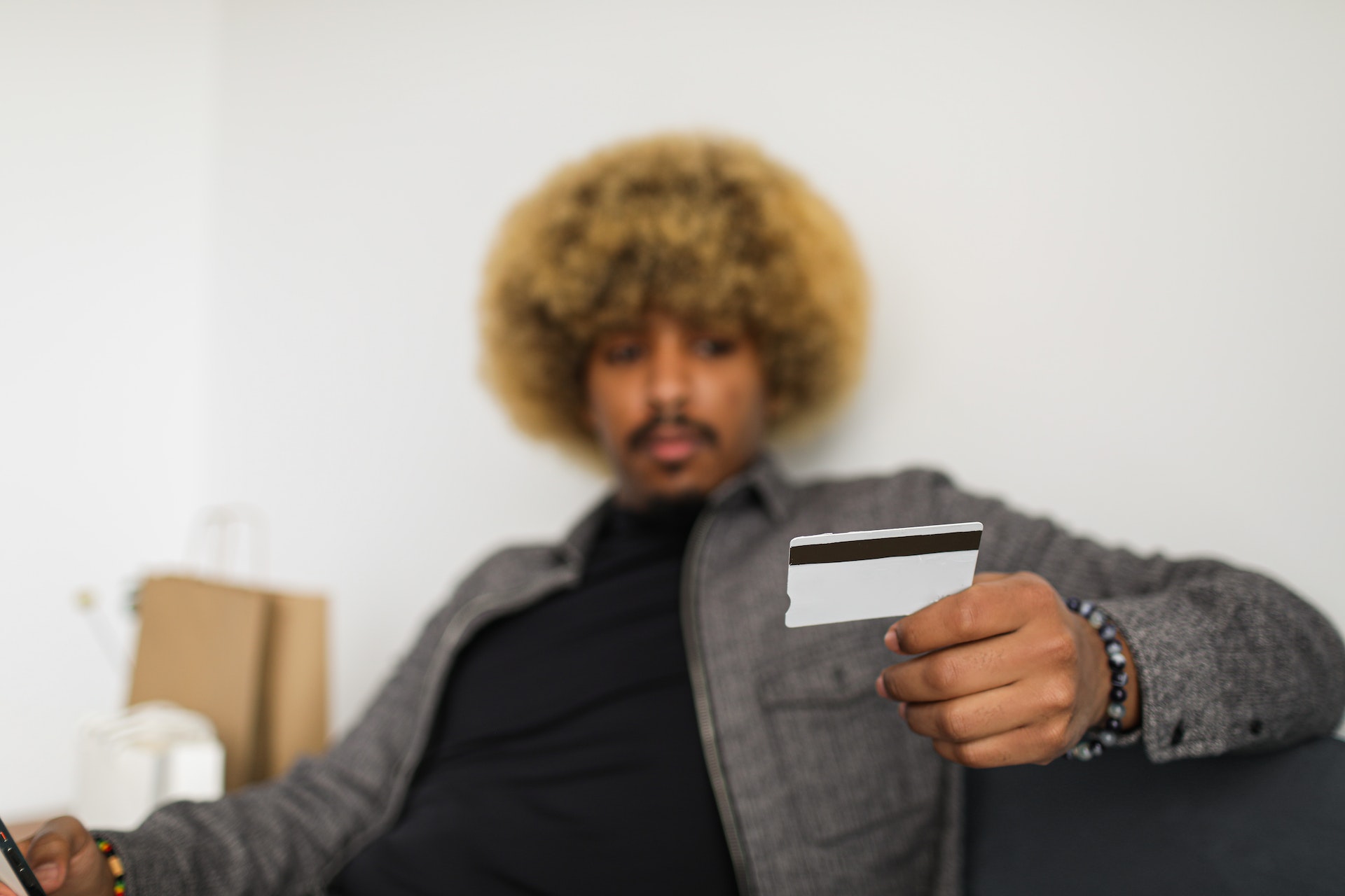A man holding a credit card in blue jacket