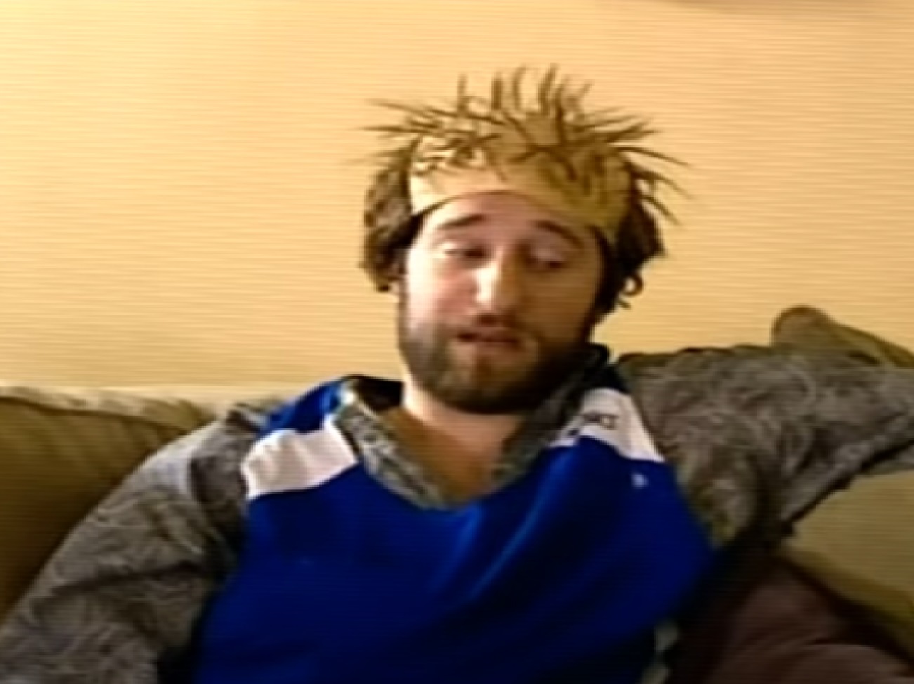 Screenshot: Dustin Diamond wearing grey and blue shirt is seating and talking - from Celebrity Fit Club (2005-10)