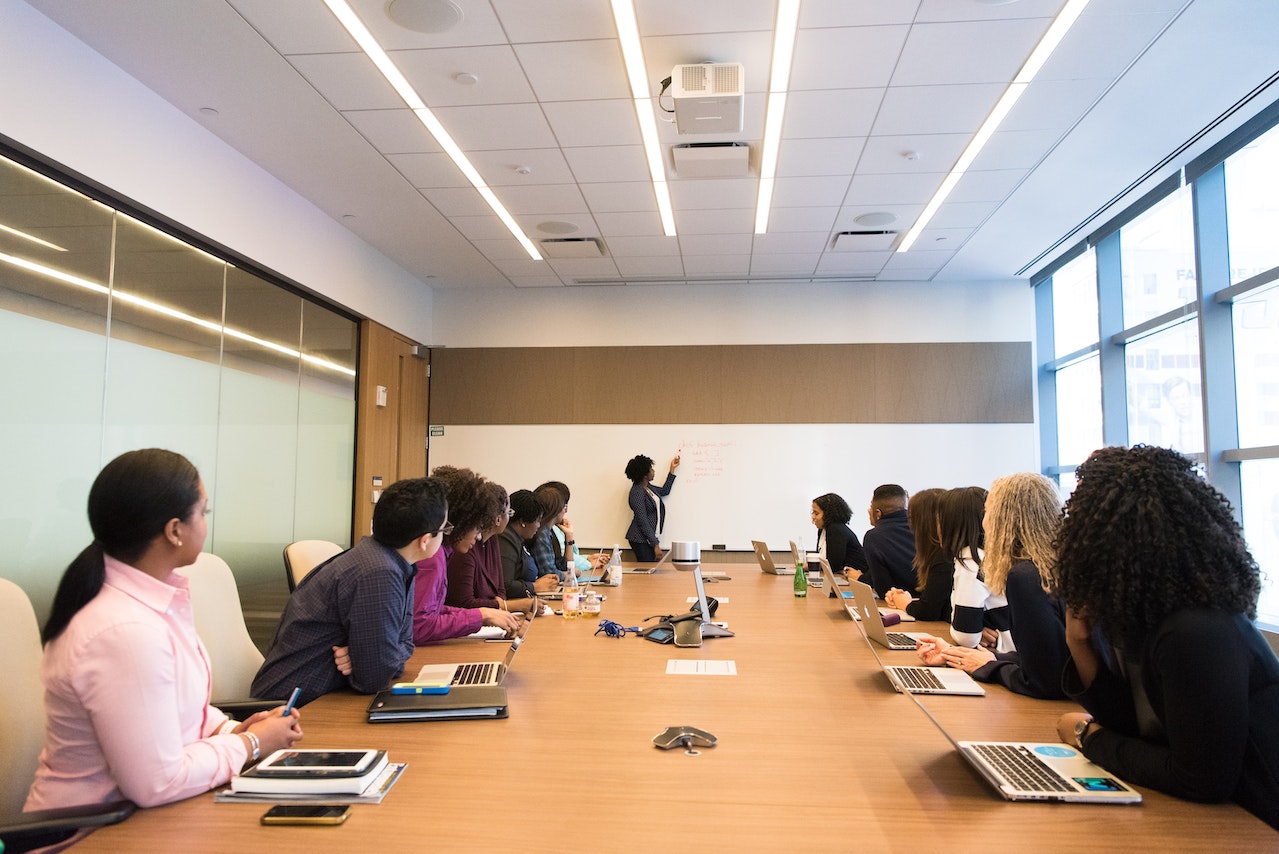 Woman is holding a meeting in office with other people.