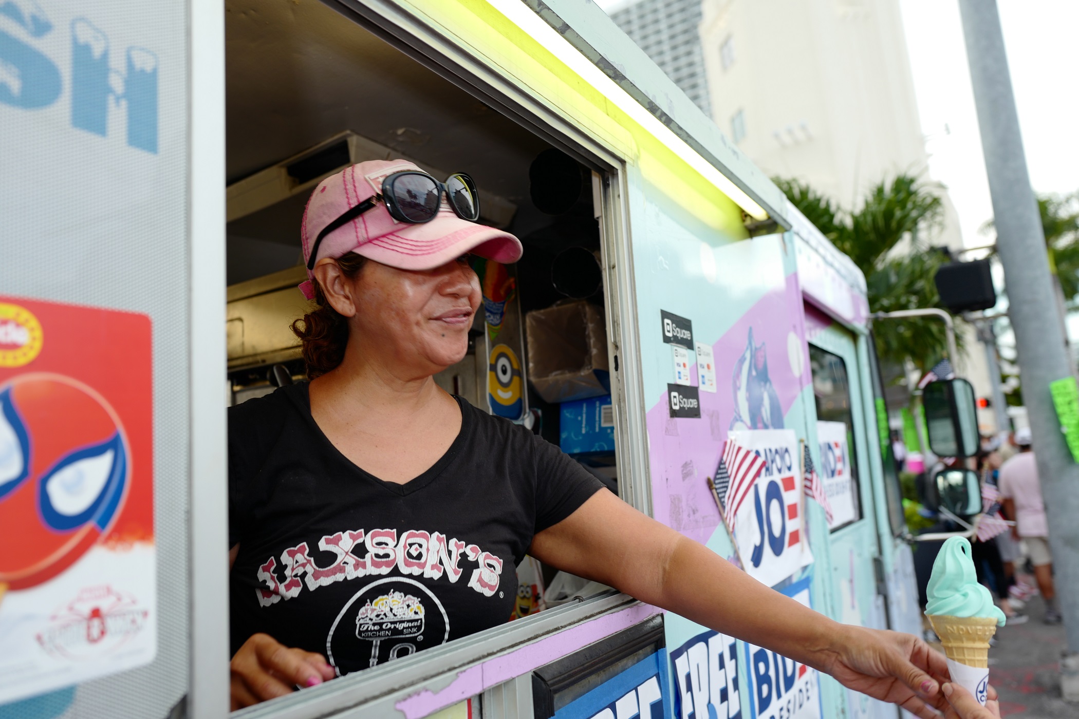 Woman is selling ice cream from ice cream truck.