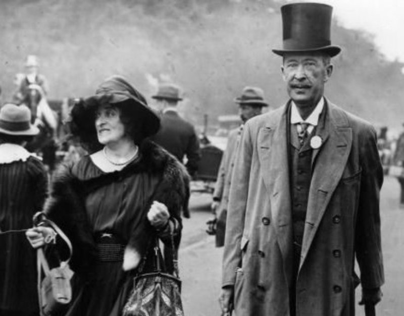 George Herbert, 5th Earl of Carnarvon and wife outside in coats