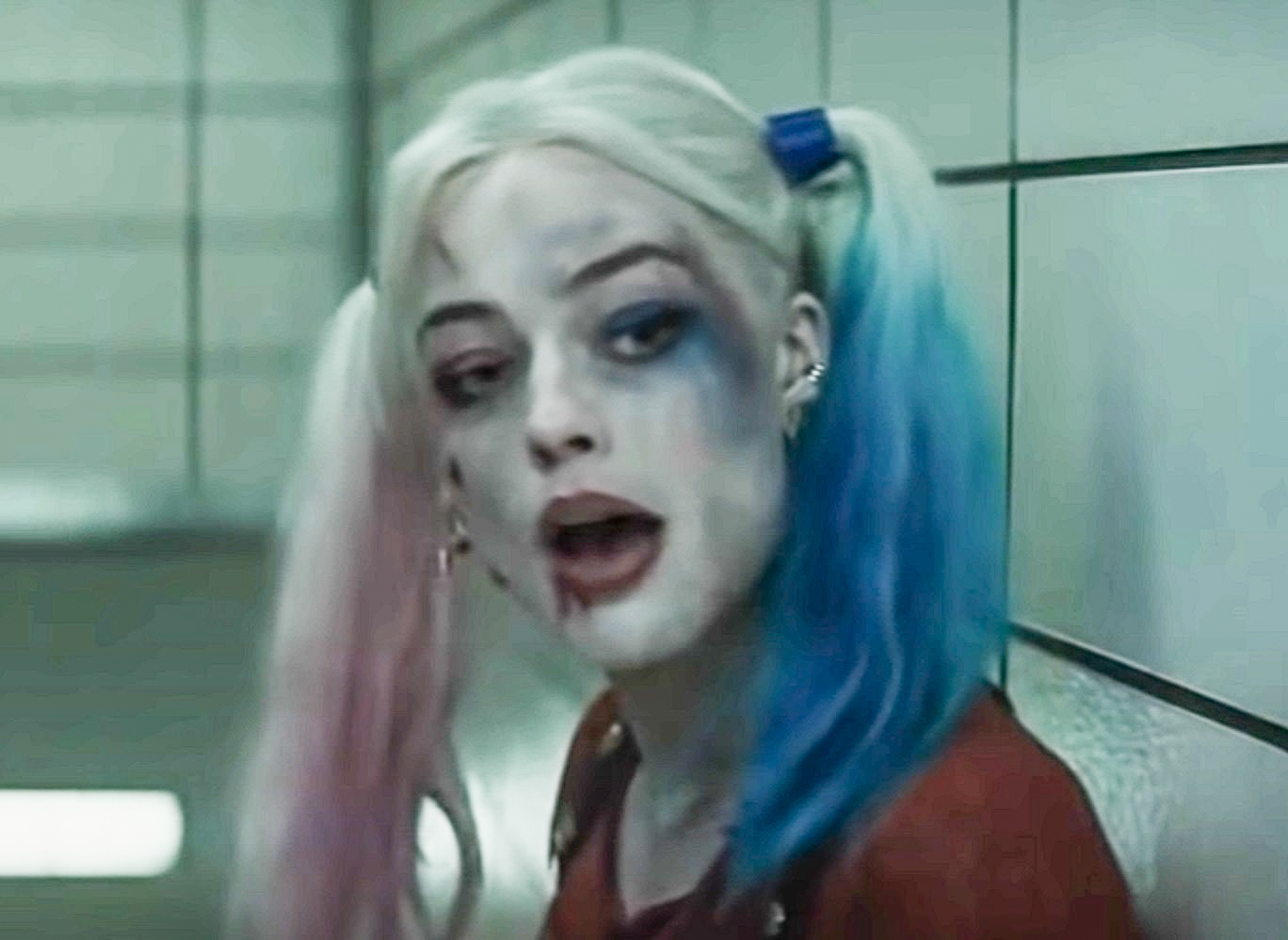 Screenshot: Harley Quinn (Margot Robbie) wearing red shirt is looking at side - from Suicide Squad (2016)