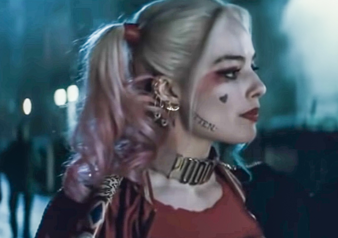 Screenshot: Harley Quinn (Margot Robbie) wearing red shirt is looking at side - from Suicide Squad (2016)
