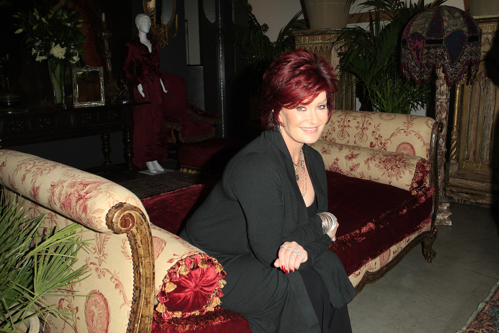 sharon osbourne sitting on a couch in black jacket