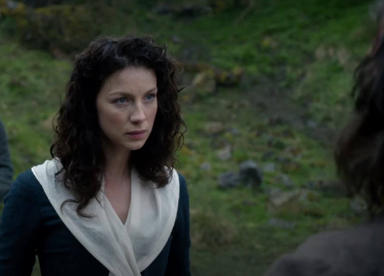 Screenshot: Claire Fraser wearing black and white dress is standing outside - from Outlander (Tv Series)