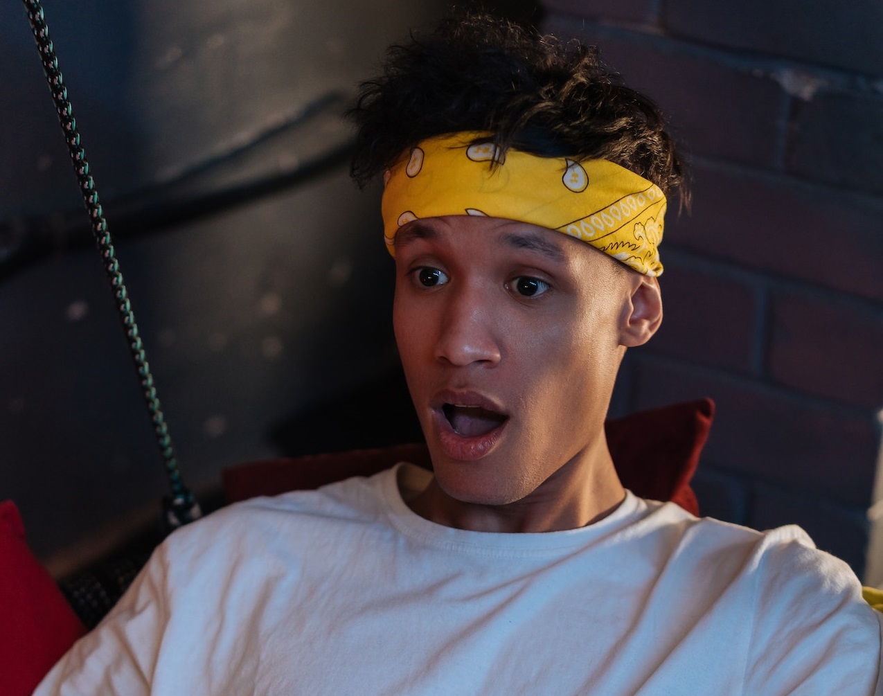 Young man wearing white shirt is looking shocked.