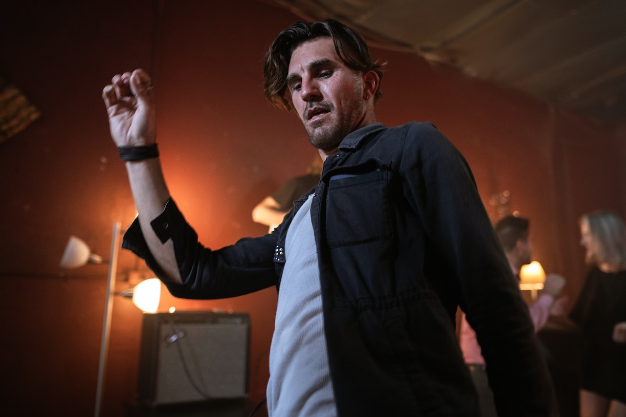 Man wearing black shirt is dancing in the club.