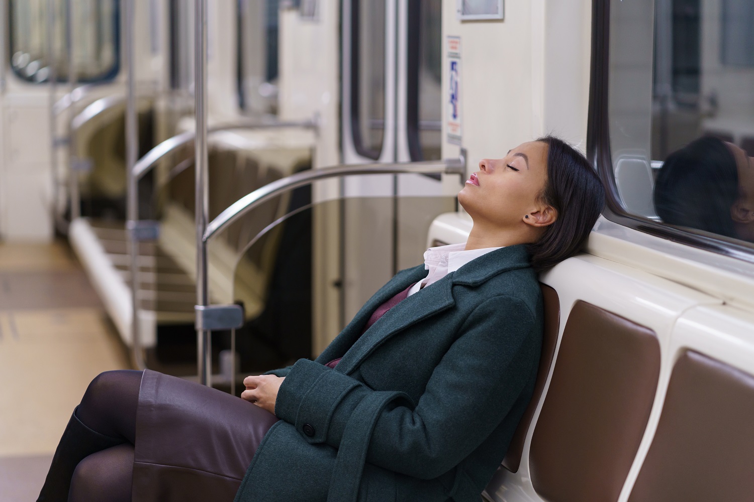 Tired businesswoman sleeping in subway returning late from work.