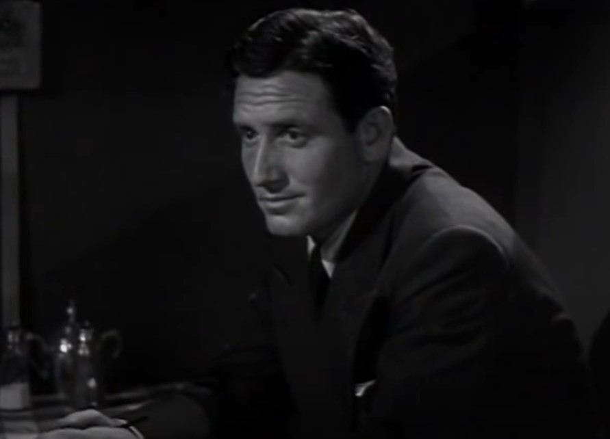 Spencer Tracy in Mannequin  sitting at a desk in suit