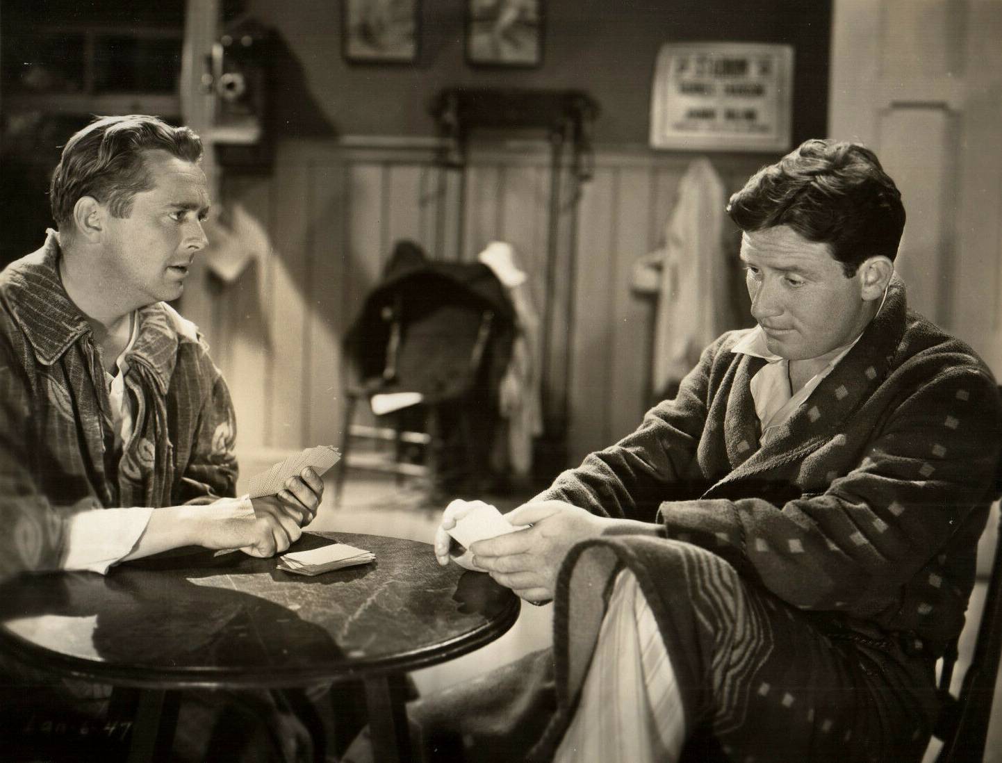 James Dunn and Spencer Tracy playing cards in home wear
