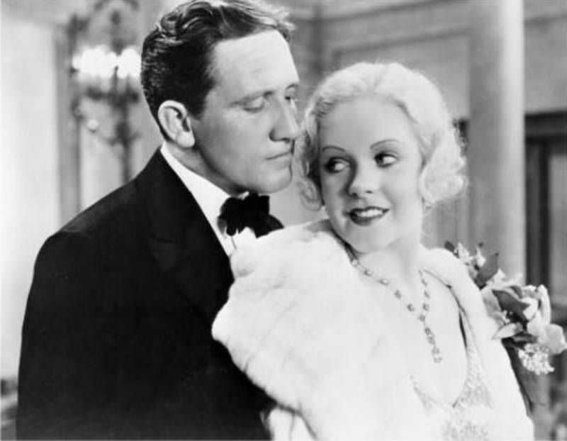 Spencer Tracy & Alice Faye looking at each other in formal wear