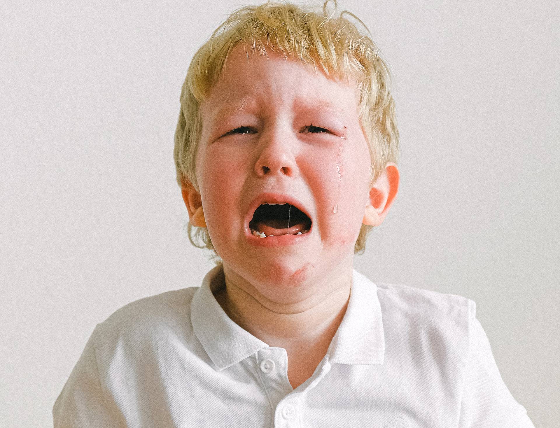 boy in white polo shirt crying