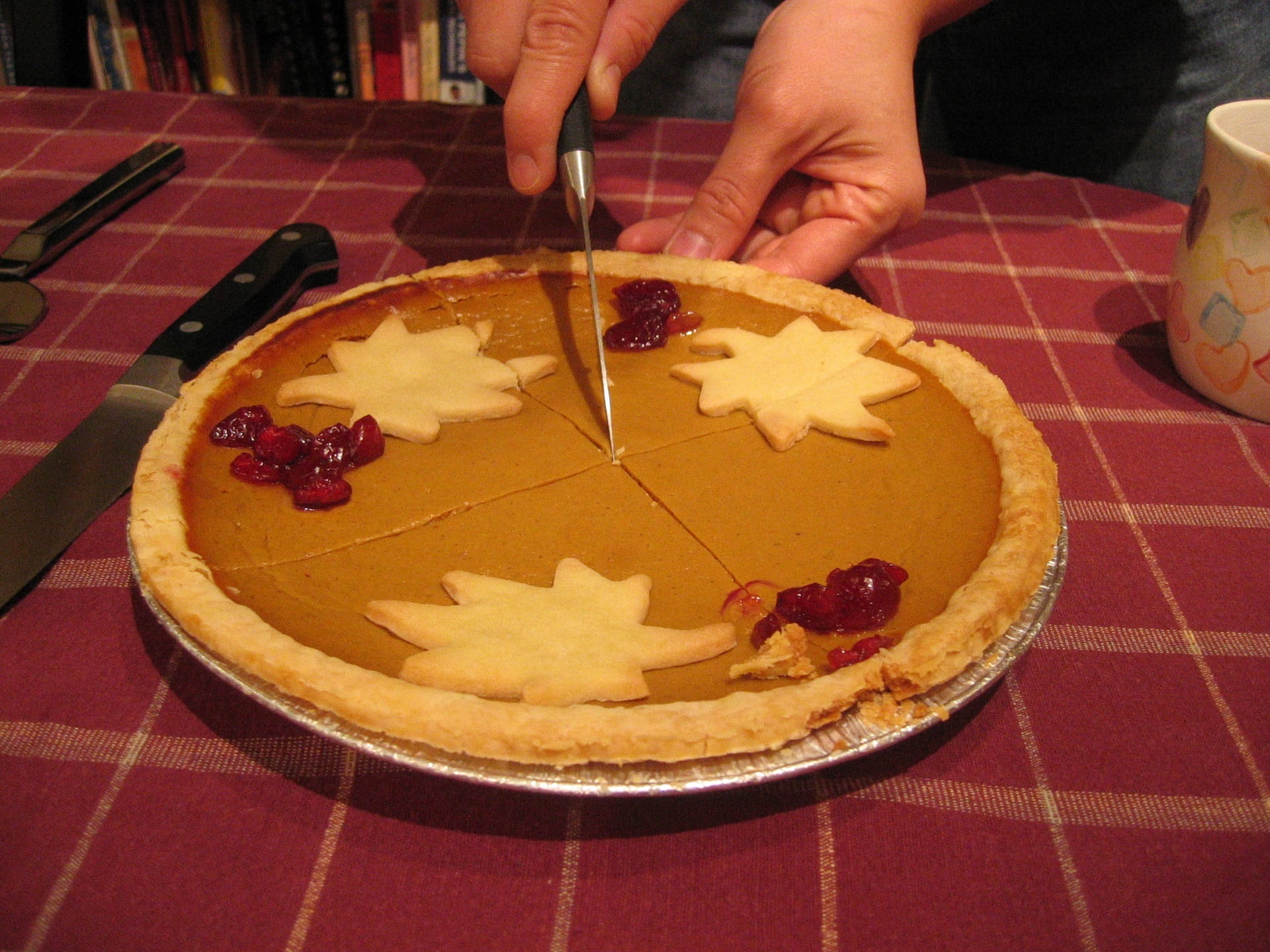 Person slicing pumpkin pie