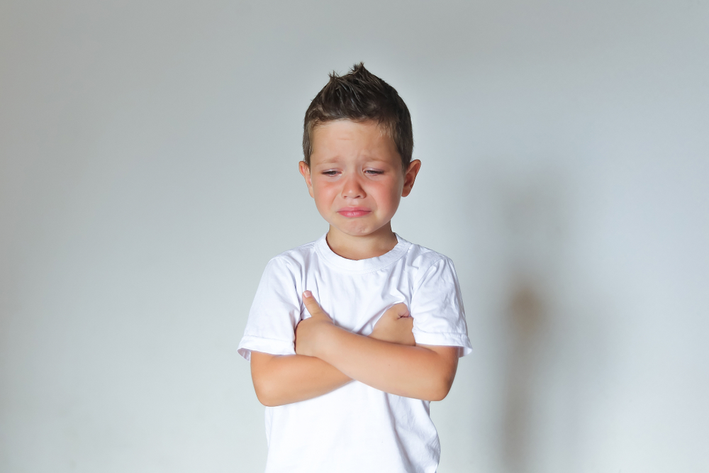 sad little boy in white t-shirt crying