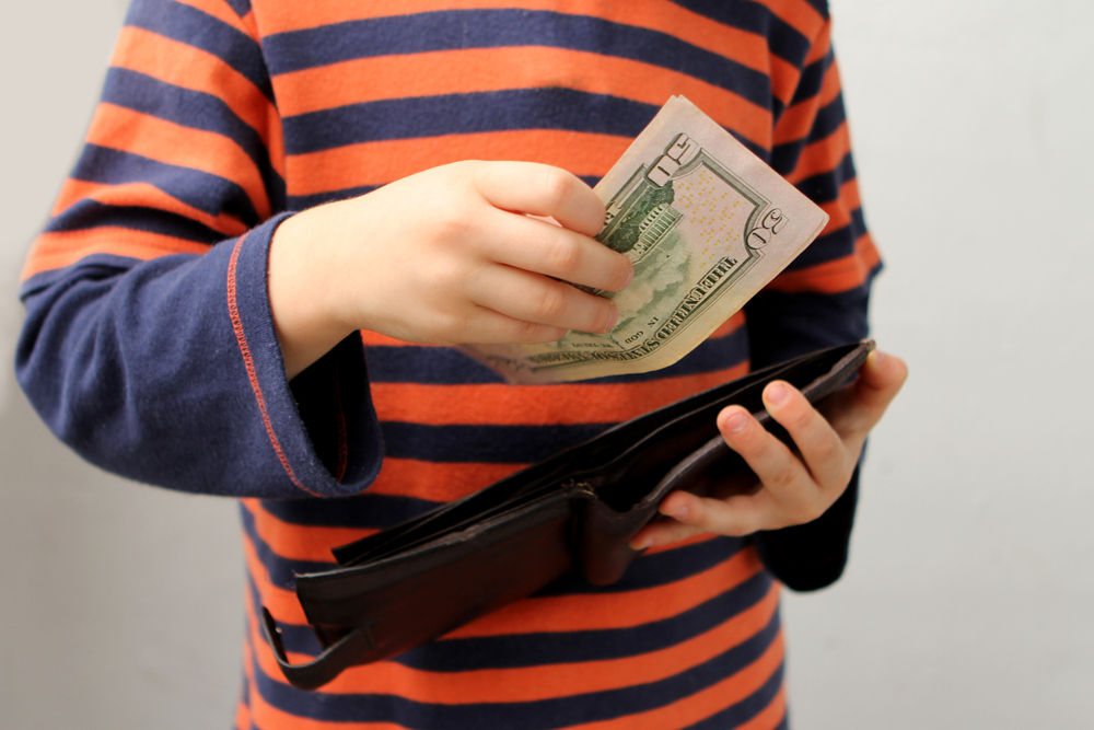 kid in striped t-shirt stealing money from wallet