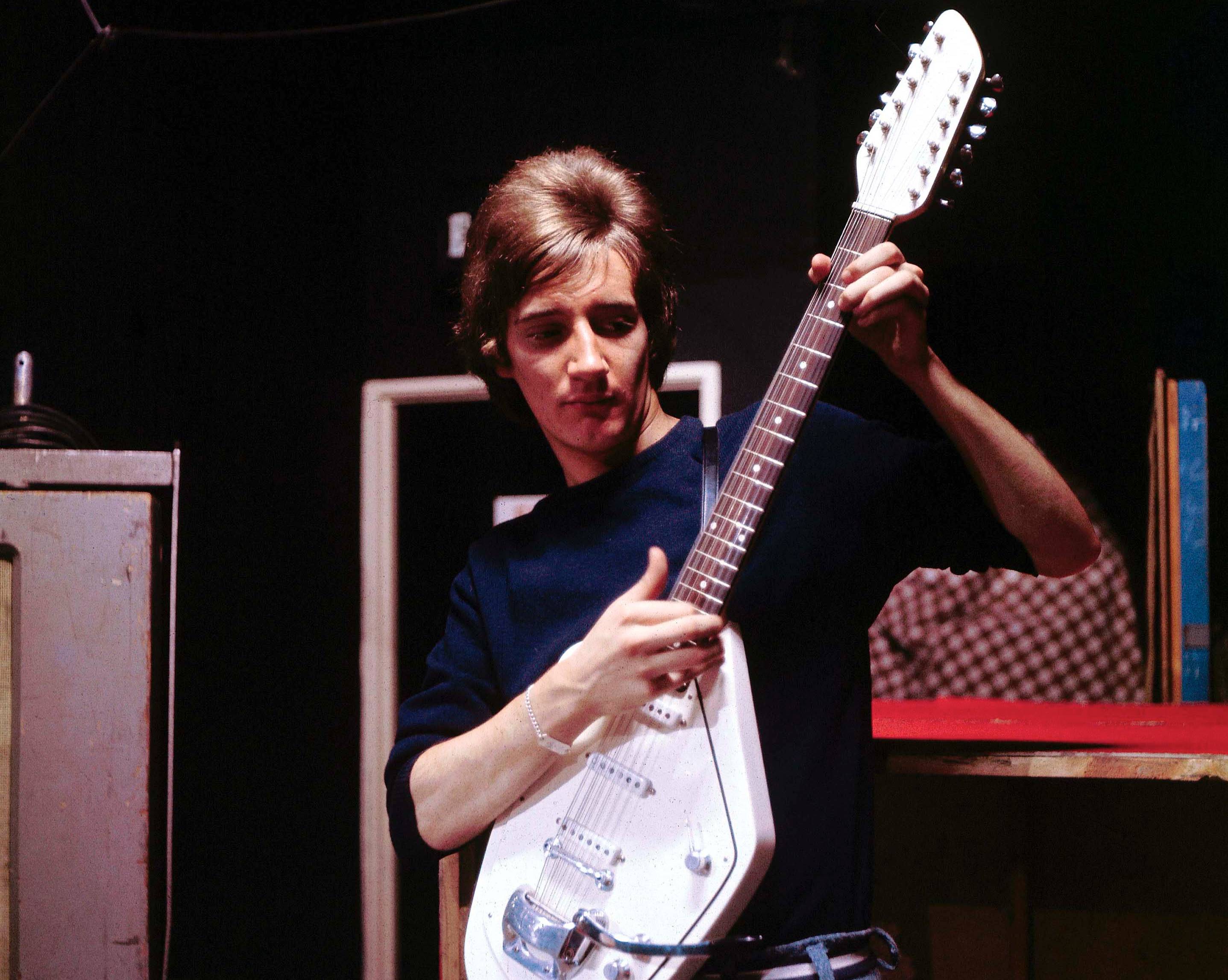Photo of Rod STEWART playing a guitar in blue sweater